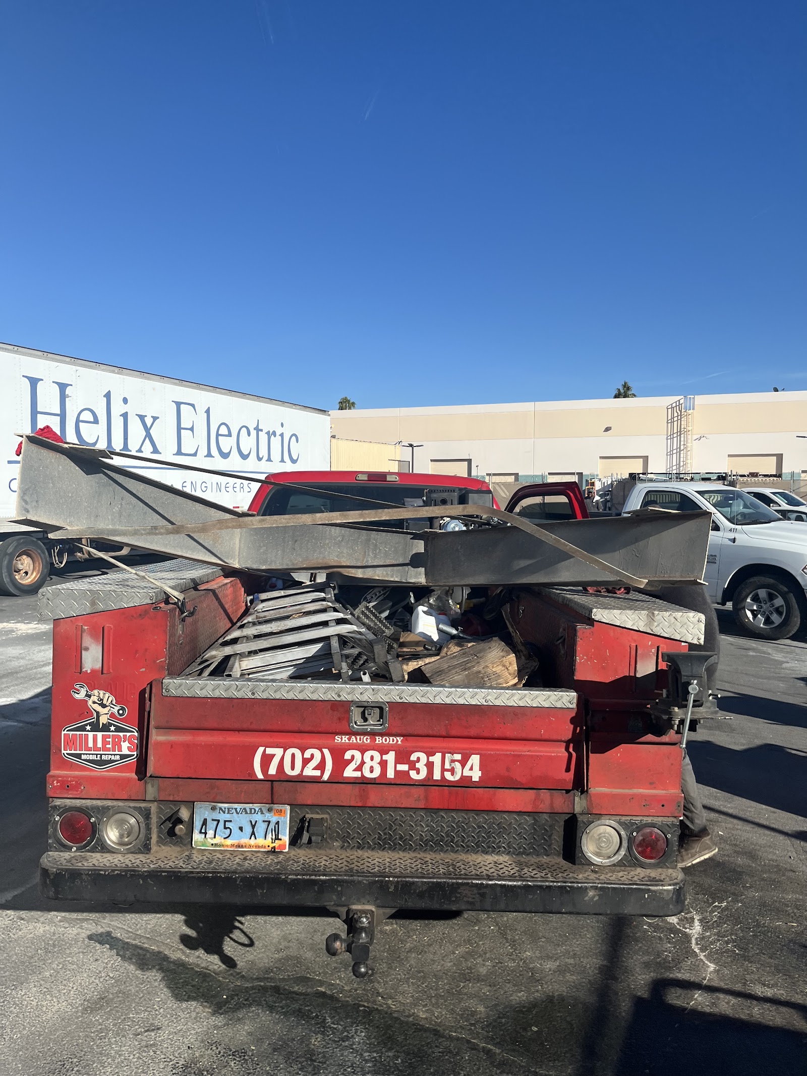 Red Miller's Mobile Repair service truck bed loaded with tools and materials, phone number (702) 281-3154 visible