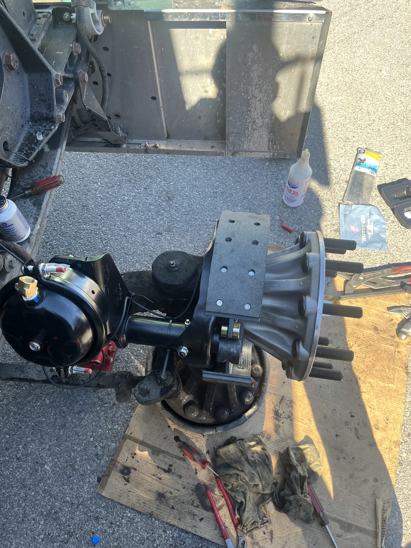 Rebuilt truck axle hub, brake chamber and slack adjuster staged on cardboard