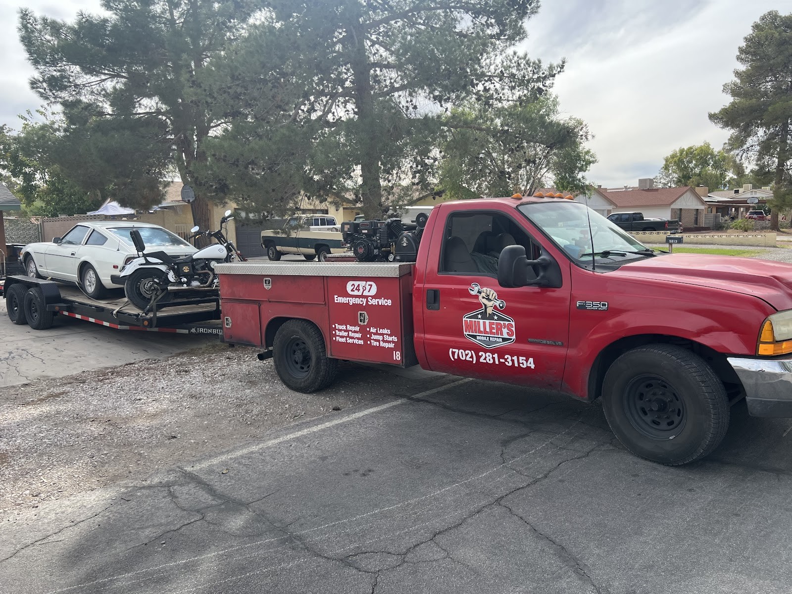 Red Ford F-350 Super Duty service truck towing a trailer loaded with a car and motorcycles, marked with Miller's Mobile Repair branding and phone (702) 281-3154